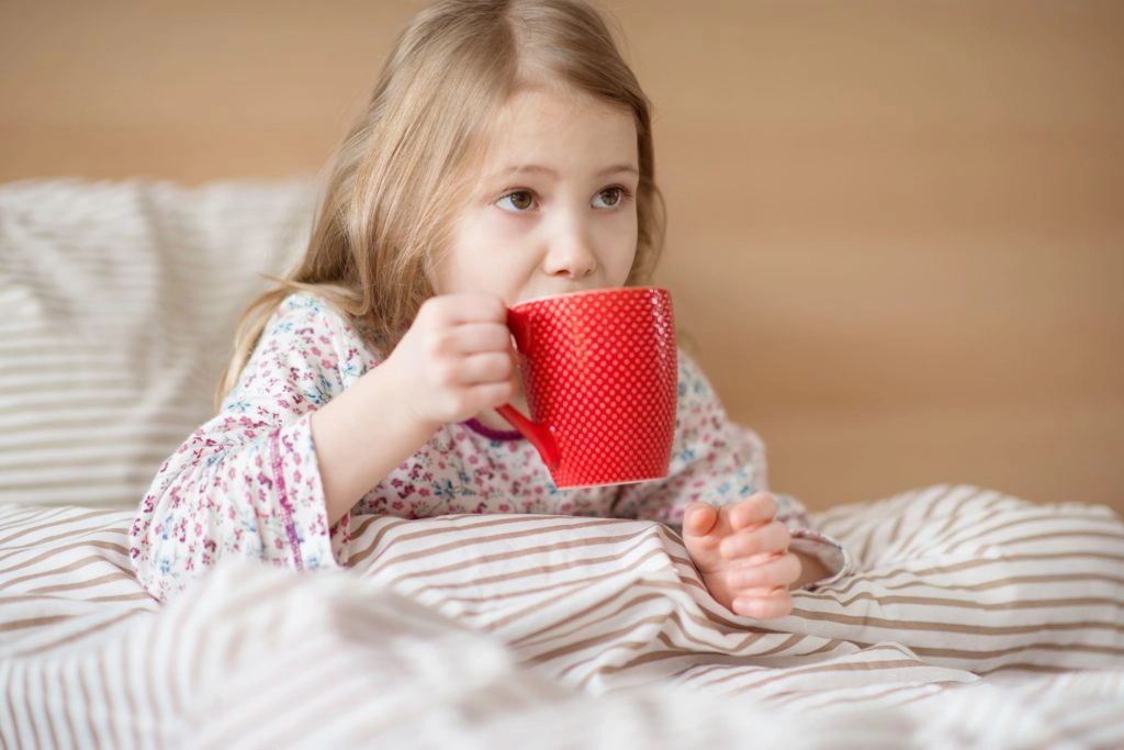 krankes Kind im Bett mit Tee