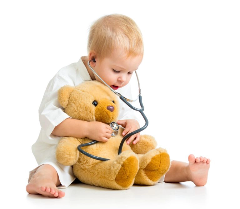 kleiner junge untersucht mit Stethoskop seinen Teddybär